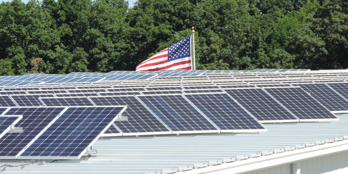 roof mounted solar panels metal building with American flag