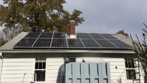 A solar panel system installed on the roof of a small home.