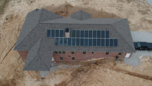 An aerial large home with roof-mounted solar panels.