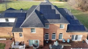 An overhead image of a large single-family home with solar panels on the roof.