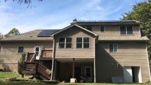 A single-family home with beige widing has new solar panels installed on the roof.