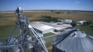 An aerial image of a large industrial facility in a remote area that has roof-mounted solar panels.