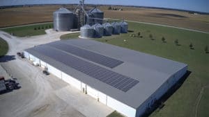 A solar panels array installed on the flat roof of a large commercial building.