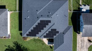 An overhead view of solar panels installed on the roof of a large home.